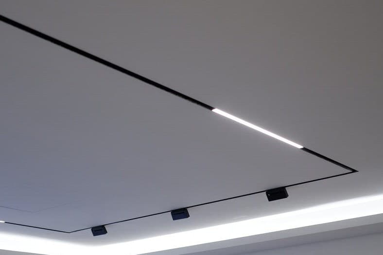 Layered lighting in a Singapore living room with a false ceiling